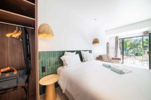 a bedroom with a large white bed and a window at Les Capucines Saint Tropez in Saint-Tropez