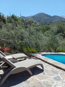 a patio with two chairs and a swimming pool at "Villa Kastania" Melidoni, Chania, Crete in Melidhónion +40 photos
