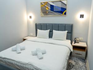a small room with a bed with white sheets at Express Tashkent Hotel&Spa in Tashkent