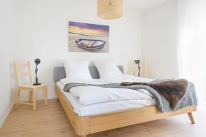 a bedroom with a bed with white sheets and a blanket at Zweitraum in Oldenburg in Oldenburg