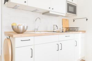 a kitchen with white cabinets and a sink at Zweitraum in Oldenburg in Oldenburg +67 photos