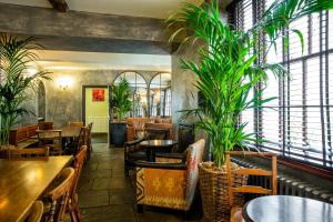 a restaurant with tables and chairs and plants at The Angel Hotel in Abergavenny