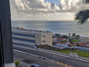 a view of a building with the ocean in the background at Hotel Natal Plaza com piscina, academia, 100m da praia de Ponta Neg in Natal