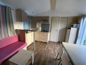 a small kitchen with a pink couch in a room at Camping 5 étoiles - Parc aquatique - eebdba in Mézos +13 photos