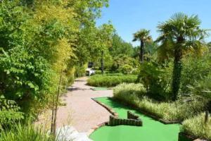 a garden with a green pond with palm trees at Camping 5 étoiles - Parc aquatique - eebdba in Mézos