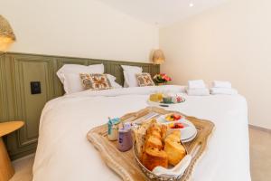 a tray of sandwiches and bread on a bed at Les Capucines Saint Tropez in Saint-Tropez