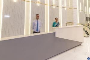 Un homme et une femme se tenant derrière un comptoir dans l'établissement Terra Bliss Lake Bhimtal Resort And Spa, à Bhimtal