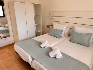 ein Schlafzimmer mit einem großen Bett mit Handtüchern darauf in der Unterkunft DUNASOL Home, by Comfortable Luxury in Corralejo