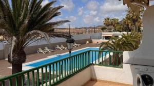 einen Balkon mit Blick auf den Pool und den Strand in der Unterkunft DUNASOL Home, by Comfortable Luxury in Corralejo