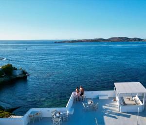 two people standing on the deck of a boat in the water at Nostos Studios in Parikia