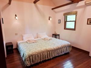 a bedroom with a bed and a window at ローズウッドガーデンアンドヴィラ-Private Onsen Villa in Nasu- in Nasu