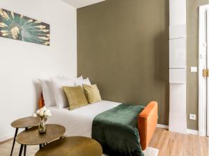 een slaapkamer met een bed en 2 tafels bij Merveil - Family Suite - Opera - Caumartin II in Parijs