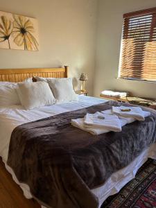 ein Schlafzimmer mit einem großen Bett mit Handtüchern darauf in der Unterkunft Dottie's charming cottage two bedroom apartment and workspace in Paarl