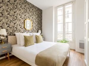 een slaapkamer met een groot bed en een met bloemen bedekte muur bij Merveil - Family Suite - Opera - Caumartin II in Parijs