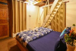 ein Schlafzimmer mit einem Bett und einer Treppe im Hintergrund in der Unterkunft Moksha Woodhouse in Kasol