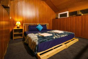 ein Schlafzimmer mit einem Bett in einem Holzzimmer in der Unterkunft Moksha Woodhouse in Kasol