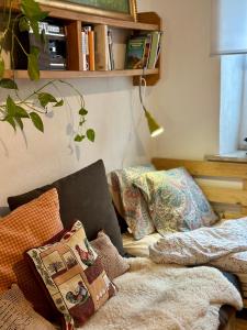 una pila de almohadas sentadas en un sofá en una habitación en Zimmer in rustikalem alten Haus, en Tiefenpölz