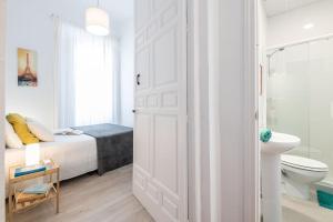 a white bedroom with a bed and a bathroom at Apartamentos Alcazaba in Málaga +208 photos