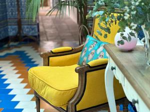 a table with two yellow chairs and a vase on it at Hostal Casa Alborada in Conil de la Frontera +37 photos
