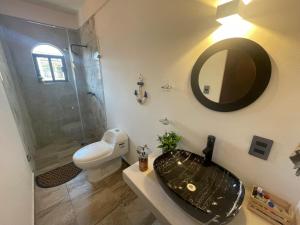 a bathroom with a sink and a toilet and a mirror at Casa Quiñones in Cedro