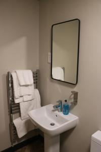a bathroom with a white sink and a mirror at Black Dog Inn in Bolton +26 photos
