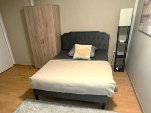 a bedroom with a bed with a blue headboard at Gemütliche Appartement 4 - mit Küche und Bad zur Eigennutzung -Schuster Homes- in Alvesse