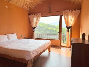 a bedroom with a bed and a large window at Du Gia Panorama Ecologde in Làng Cac