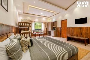 a bedroom with a bed and a living room at StayVista at Lakshmi's Retreat - Kotagiri in Kotagiri
