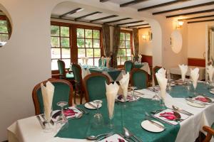 a dining room with tables and chairs with plates and wine glasses at Rosemundy House Hotel in St. Agnes