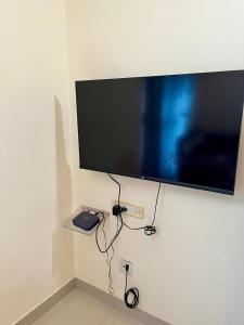 ein Flachbildfernseher, der an einer Wand hängt in der Unterkunft 3BHK Spacious Villa near Rajagiri Hospital in Ernakulam