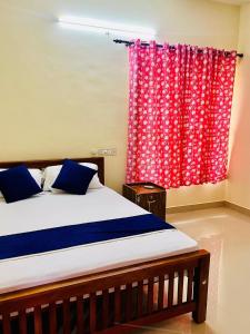 ein Schlafzimmer mit einem Bett und einem roten Vorhang in der Unterkunft 3BHK Spacious Villa near Rajagiri Hospital in Ernakulam + 7 Fotos