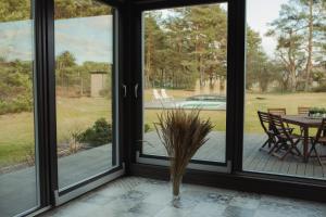 a screened porch with a view of a table and chairs at Berti in Upesgrīva