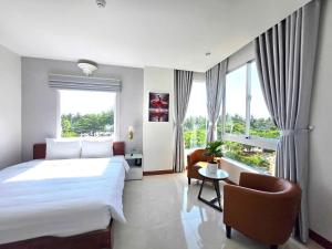 a hotel room with a large bed and a chair at Oasis Home in Nha Trang