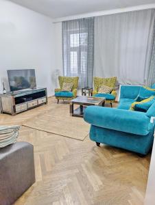 sala de estar con sofás azules y TV en Lovely 2BR Apartment in Praterstern Area, en Viena