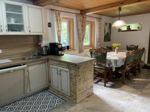 a kitchen with a table and a dining room at Chata Rusalka in Nemecká