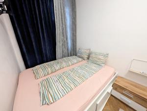 Una cama con dos almohadas encima en una habitación. en Lovely 2BR Apartment in Praterstern Area, en Viena