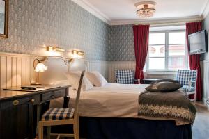 a bedroom with a bed and a desk and a television at Scandic Gamla Stan in Stockholm