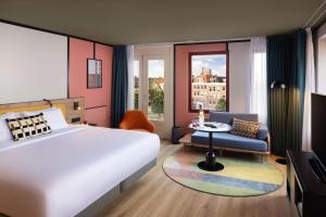 阿姆斯特丹Avani Museum Quarter Amsterdam Hotel - previously NH Amsterdam Museum Quarter的一间卧室，里面有一张床、一把椅子和一张桌子