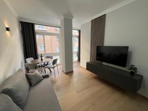 a living room with a couch and a tv and a table at Apartamento Solimar in Torre del Mar