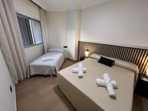 a bedroom with two beds with towels on them at Apartamento Solimar in Torre del Mar