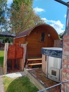 a wooden building with a stove and a house at Ferienwohnung Karnitz im Herzen von Rügen in Karnitz