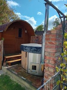 an outdoor oven in a garden next to a building at Ferienwohnung Karnitz im Herzen von Rügen in Karnitz