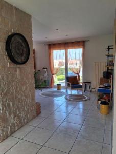 a living room with a clock on a stone wall at Gîte Refuge des Amis in La Gaubretière