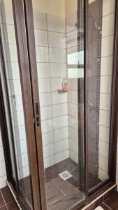 a shower with a glass door in a bathroom at Impala Suites in Mombasa