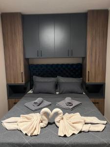 Una cama con dos toallas y dos corazones. en Apartman Dašić, en Jagodina