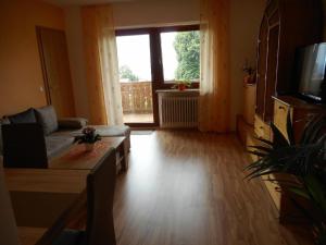 a living room with a couch and a television at Pension Jodlbauer in Schöllnach