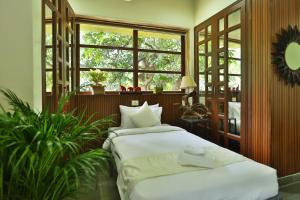 two beds in a room with a window at Nestay in Karnāla