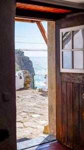 une porte donnant sur une maison avec vue sur l'océan dans l'établissement Private, romantic and cozy Room in Azenhas do Mar, à Colares