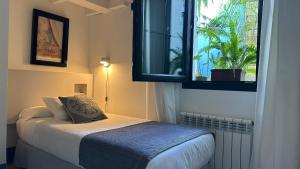 a small bedroom with a bed and a window at Hostal Casa Alborada in Conil de la Frontera