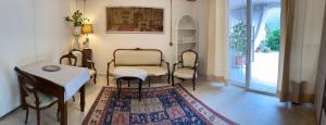 a living room with chairs and a table and a rug at Seraphic Home Garden in Taceno